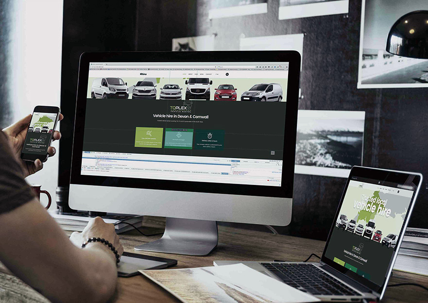 Designing a responsive website Photograph of a man viewing a car rental webste on separate devices; an imac, macbook and iphone.